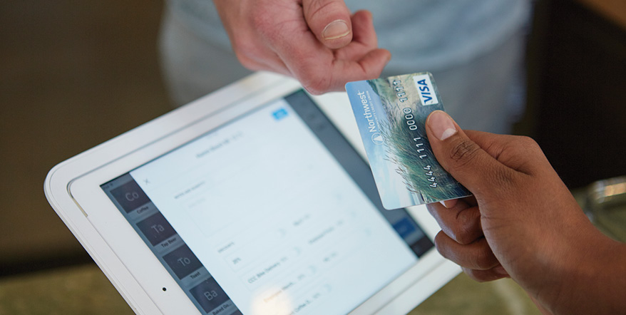 Handing a debit card to a cashier