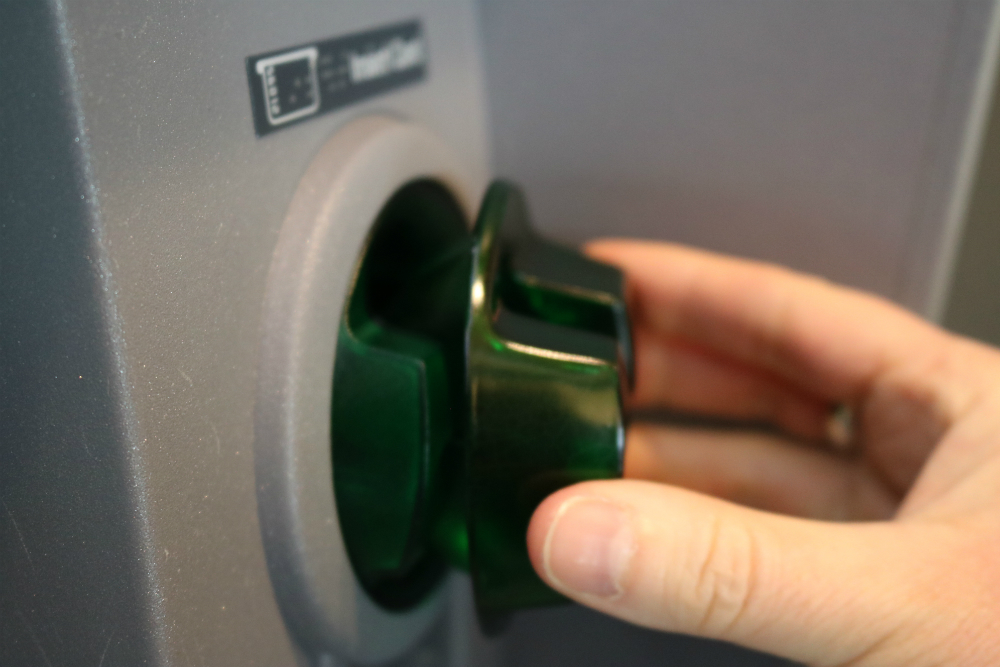 Image of skimmer being placed over an ATM card reader